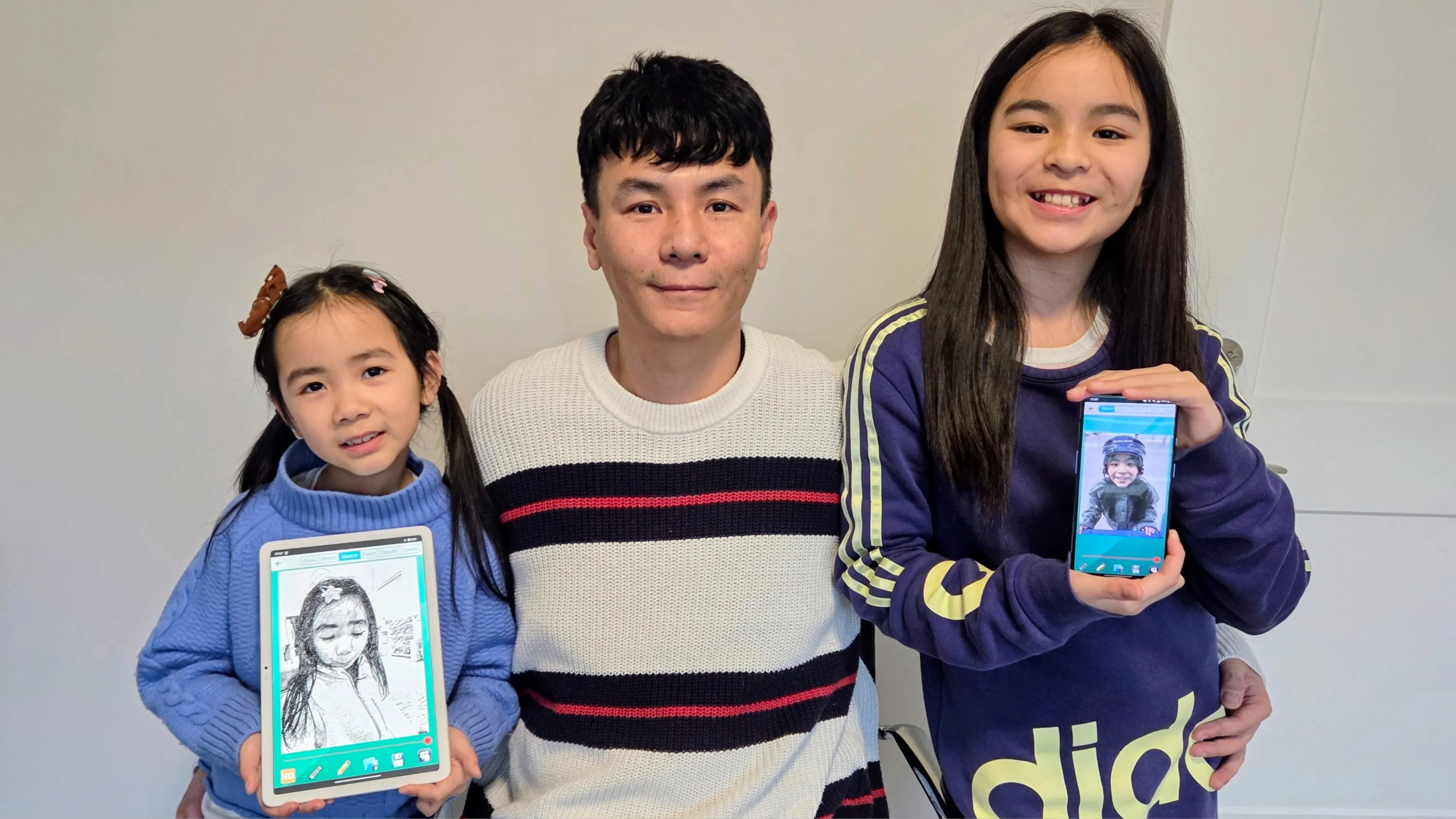 “Dad made that.” Martin Dong and his daughters hold up Pencil Sketch creations of their own.